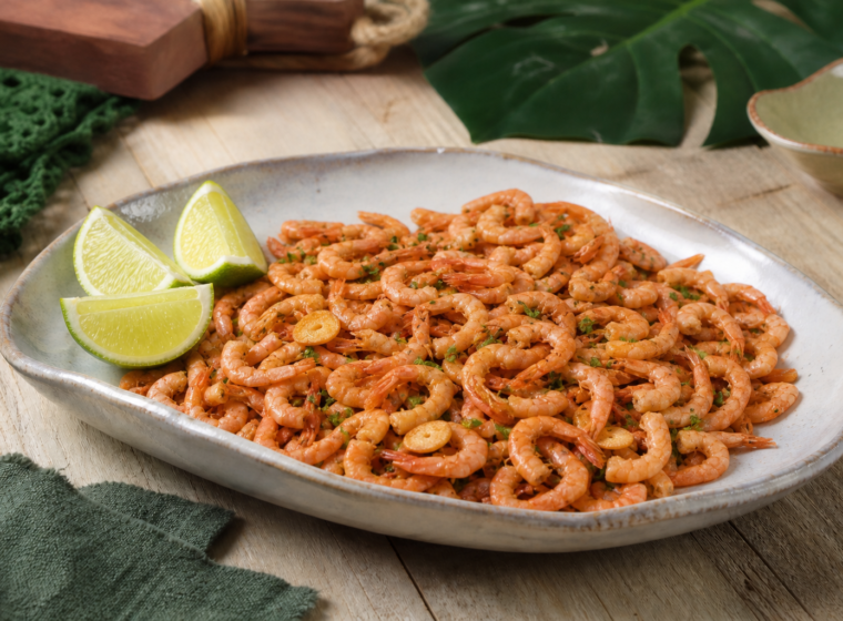 Camarões miúdos fritos com casca e alho dourado em travessa de cerâmica